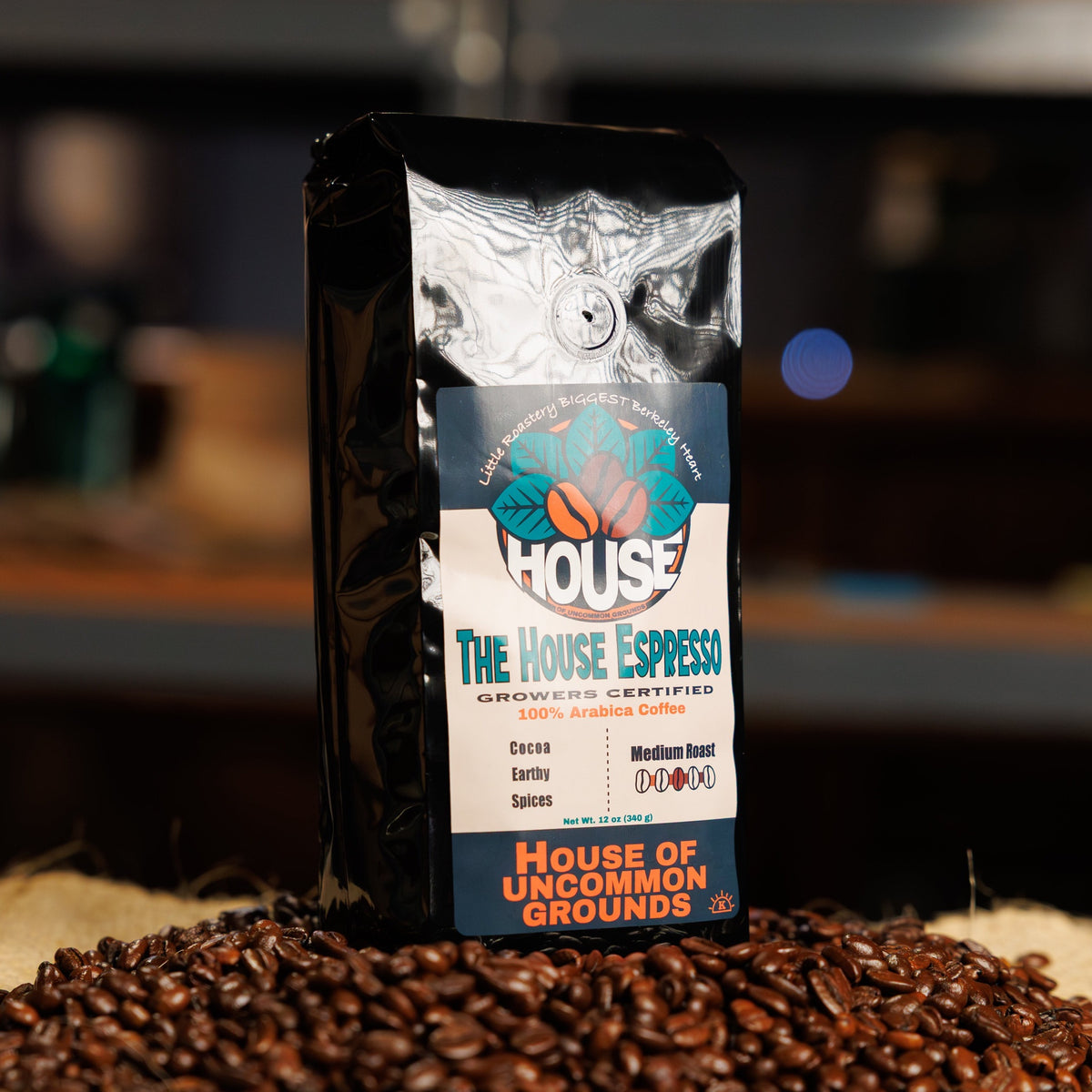 Bag of The House Espresso coffee from House of Uncommon Grounds on a bed of roasted beans