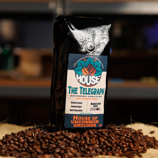 Bag of The Telegraph coffee from House of Uncommon Grounds on a bed of roasted beans